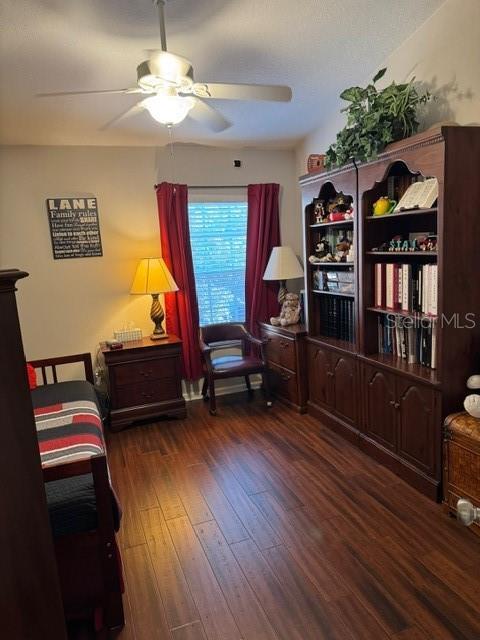 interior space with dark wood-type flooring and ceiling fan