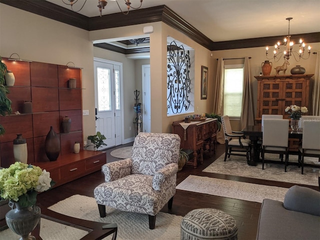 living room featuring dark hardwood / wood-style flooring, a notable chandelier, and ornamental molding