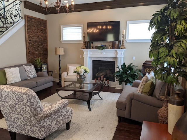 living room with a healthy amount of sunlight, a fireplace, dark hardwood / wood-style flooring, and a notable chandelier