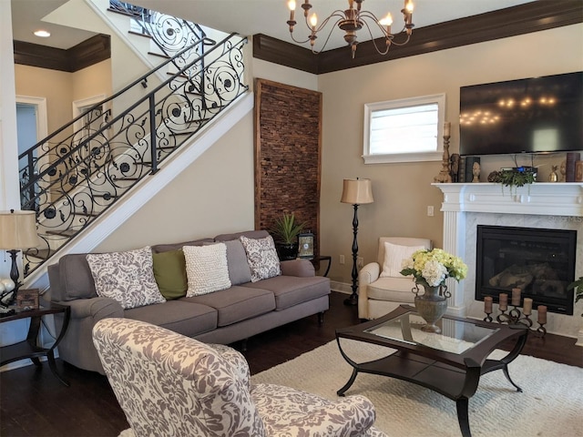 living room with an inviting chandelier, ornamental molding, hardwood / wood-style floors, and a fireplace