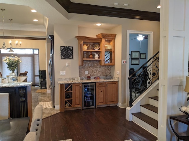 bar featuring crown molding, hanging light fixtures, dark hardwood / wood-style flooring, decorative backsplash, and beverage cooler