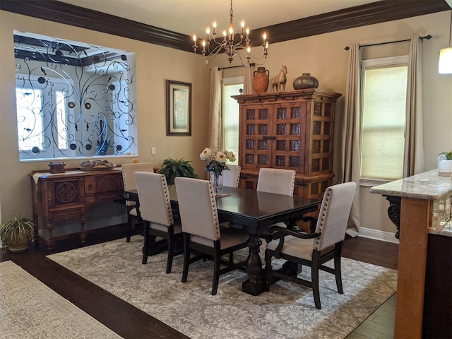 dining area featuring dark hardwood / wood-style flooring, a notable chandelier, and crown molding