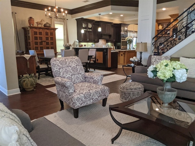 living room with an inviting chandelier, dark hardwood / wood-style flooring, and ornamental molding