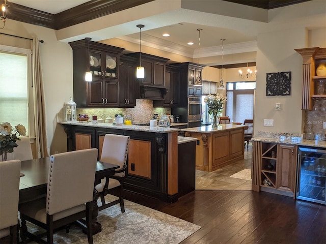 kitchen with pendant lighting, range hood, beverage cooler, a center island, and dark brown cabinets