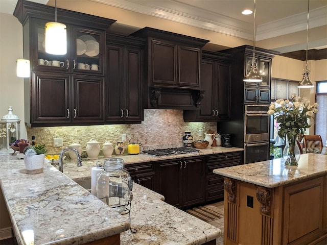 kitchen featuring decorative light fixtures, dark brown cabinets, stainless steel appliances, light stone countertops, and decorative backsplash