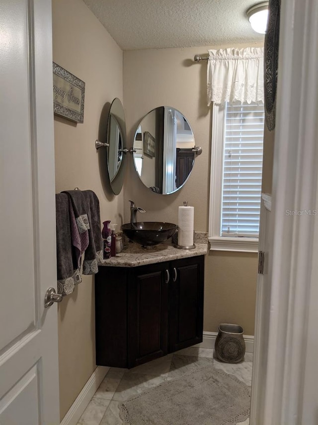 bathroom with vanity and a textured ceiling