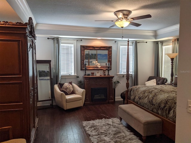 bedroom with ceiling fan, ornamental molding, dark hardwood / wood-style floors, and a textured ceiling