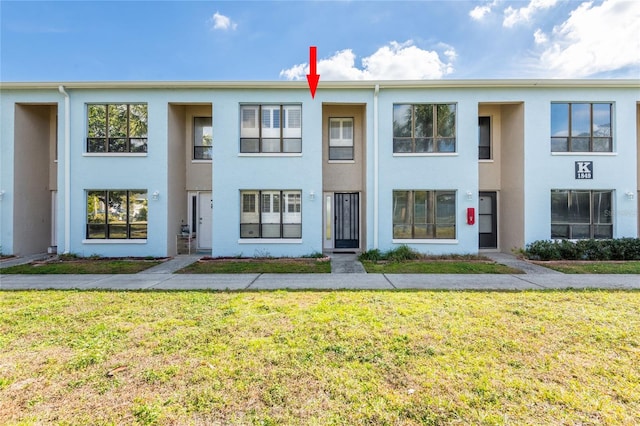 view of property with stucco siding and a front yard