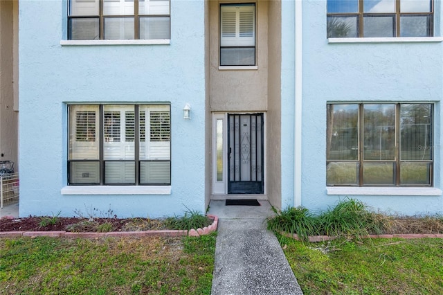 entrance to property featuring stucco siding