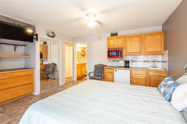 1849 Abrico Dr Unit 4, Lutz, FL 33558 - bedroom with a sink, a textured ceiling, ensuite bath, and a ceiling fan