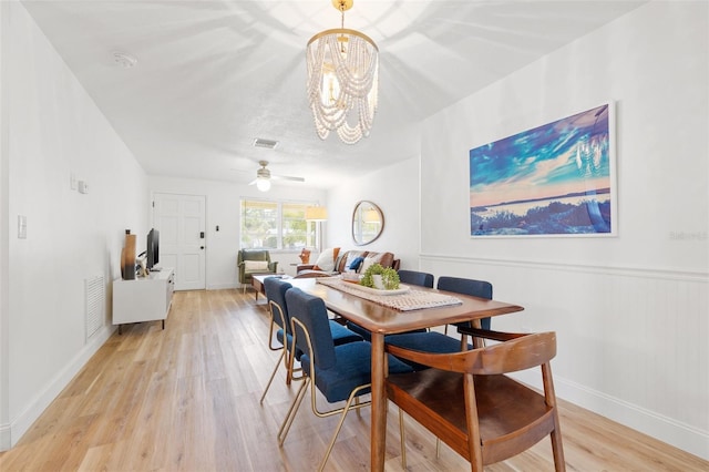 dining area featuring light wood-style floors, visible vents, baseboards, and ceiling fan with notable chandelier