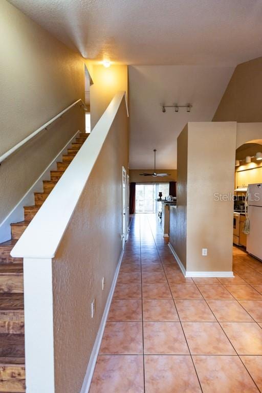 hallway with light tile patterned flooring and track lighting