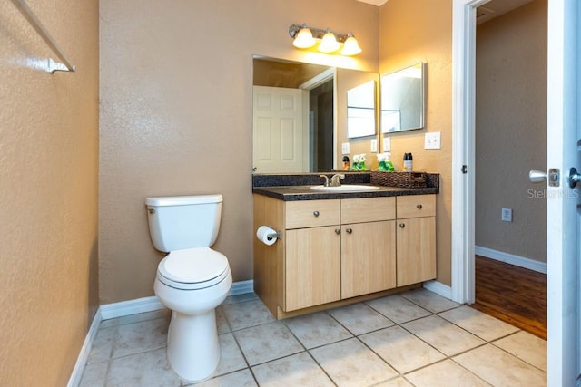 bathroom featuring tile patterned floors, toilet, and vanity