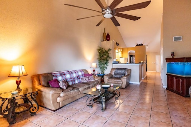 living room with light tile patterned flooring, ceiling fan, and high vaulted ceiling