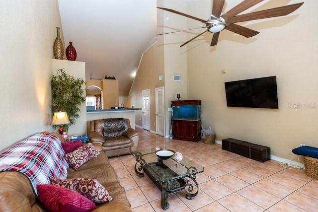 tiled living room featuring ceiling fan and high vaulted ceiling