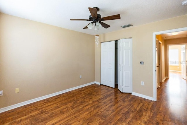 unfurnished bedroom with a closet, dark hardwood / wood-style floors, and ceiling fan