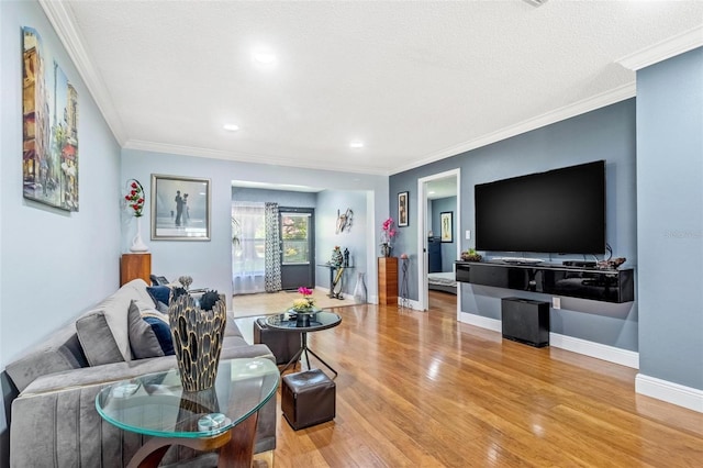 living room featuring light wood-type flooring, crown molding, a textured ceiling, and baseboards