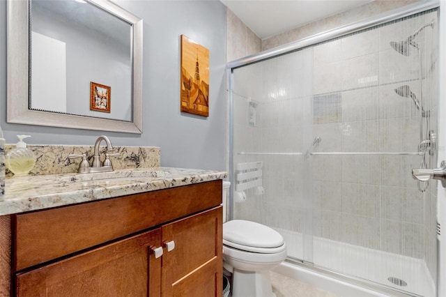 bathroom with toilet, a shower stall, and vanity