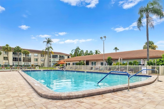 pool featuring fence and a patio