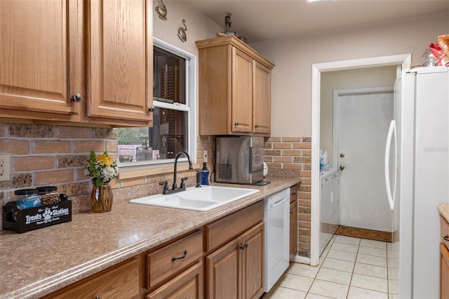 kitchen featuring light tile patterned floors, sink, white appliances, independent washer and dryer, and decorative backsplash