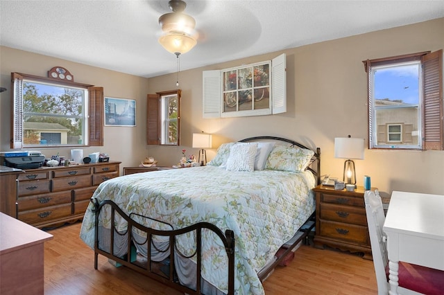 bedroom featuring hardwood / wood-style floors, multiple windows, and a textured ceiling