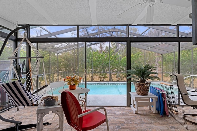 sunroom / solarium featuring ceiling fan and plenty of natural light