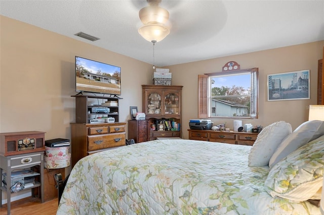 bedroom with a textured ceiling and light wood-type flooring