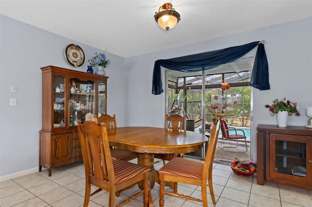 dining space featuring light tile patterned floors and a textured ceiling