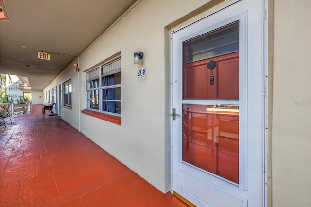 entrance to property featuring covered porch and stucco siding