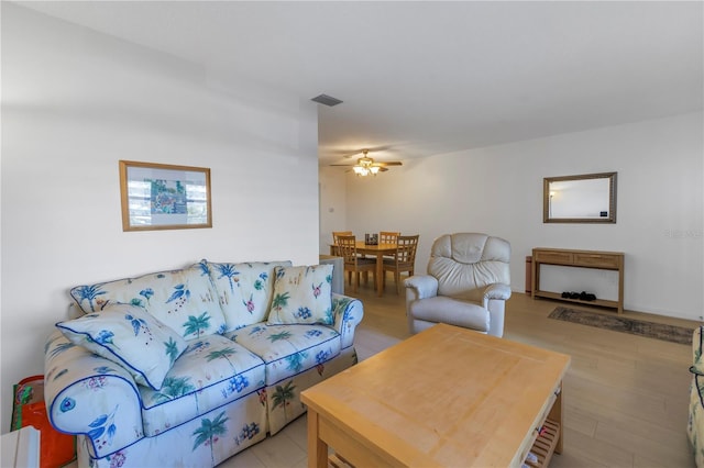 living room with ceiling fan, light wood-type flooring, and visible vents