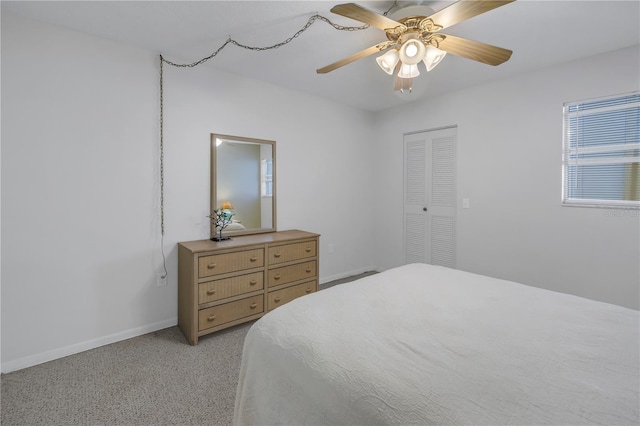 bedroom featuring a ceiling fan, a closet, light colored carpet, and baseboards