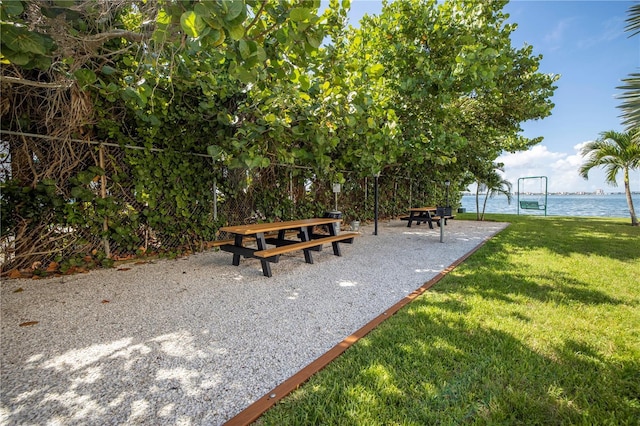 surrounding community featuring a lawn and a water view