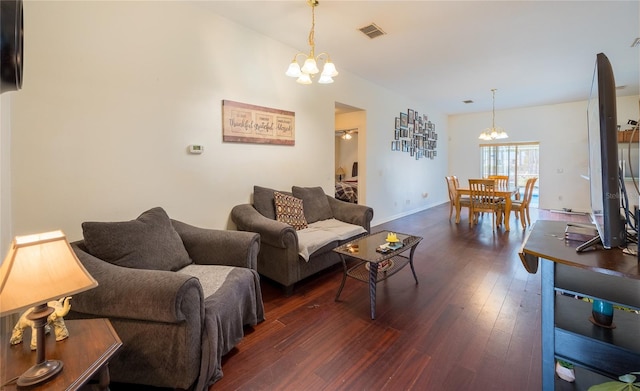 living room with an inviting chandelier and dark wood-type flooring