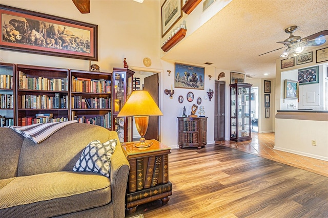 sitting room with ceiling fan, wood-type flooring, and a textured ceiling