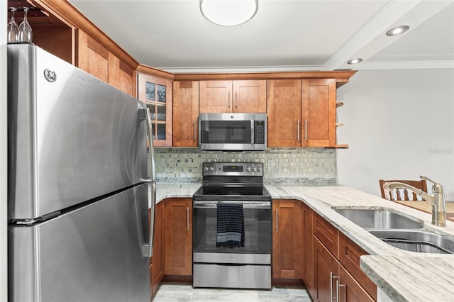 kitchen with appliances with stainless steel finishes, sink, backsplash, ornamental molding, and light stone countertops