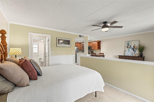 bedroom featuring crown molding, connected bathroom, a textured ceiling, and light tile patterned flooring