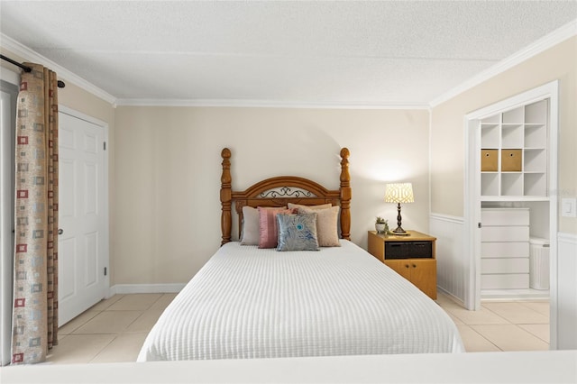 bedroom featuring ornamental molding, light tile patterned floors, and a textured ceiling