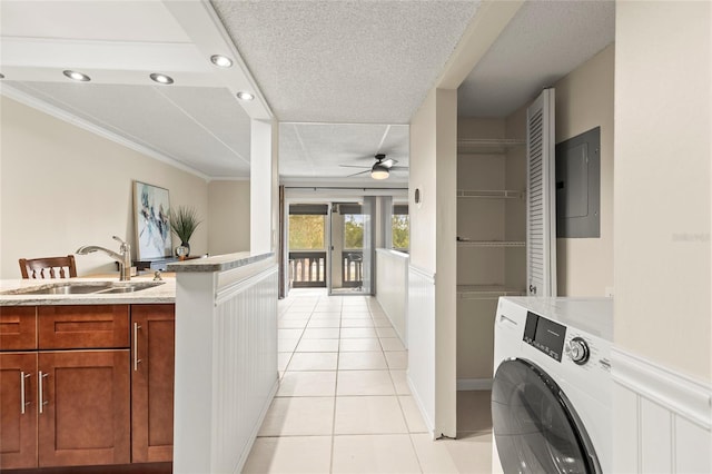 washroom with light tile patterned floors, sink, ceiling fan, electric panel, and washer / clothes dryer