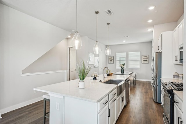 kitchen featuring a breakfast bar, hanging light fixtures, stainless steel appliances, an island with sink, and white cabinets