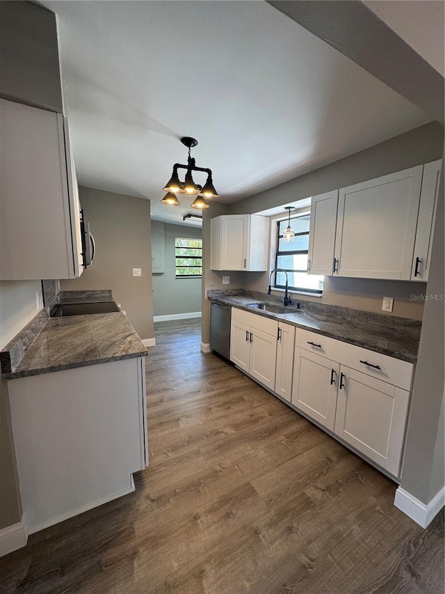 kitchen featuring stainless steel appliances, white cabinets, a sink, and dark wood-style floors