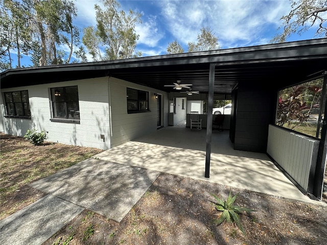 exterior space featuring driveway, concrete block siding, and a carport