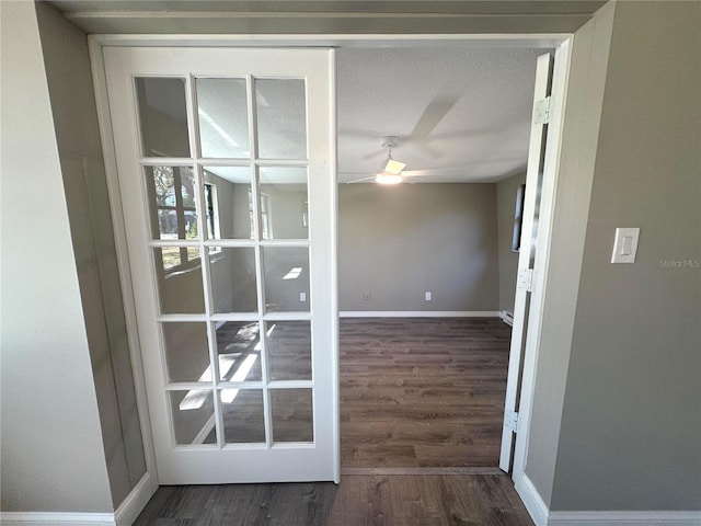 spare room featuring wood finished floors, a ceiling fan, and baseboards