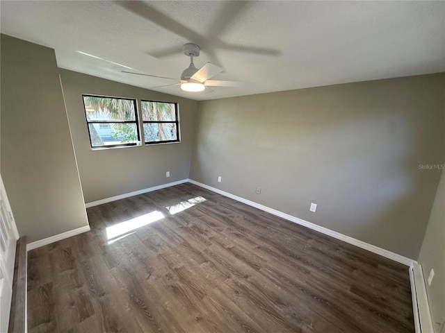 unfurnished bedroom featuring a textured ceiling, ceiling fan, dark wood-style flooring, and baseboards