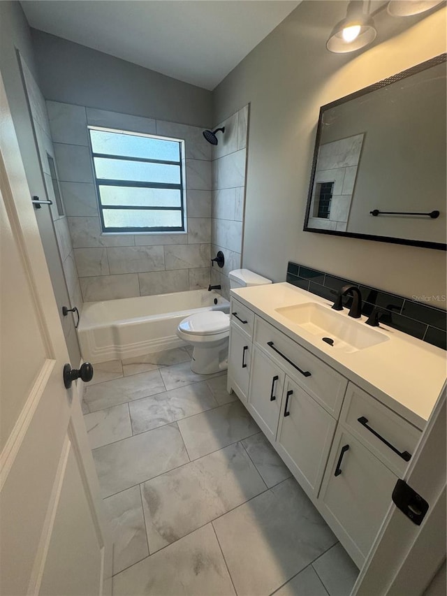 bathroom featuring toilet, lofted ceiling, marble finish floor, tub / shower combination, and vanity