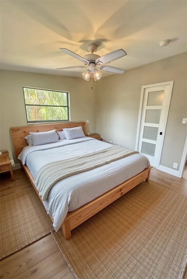 bedroom featuring light wood-style floors, ceiling fan, and baseboards