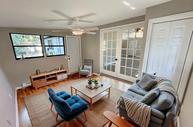 living area featuring french doors, ceiling fan, wood finished floors, and baseboards