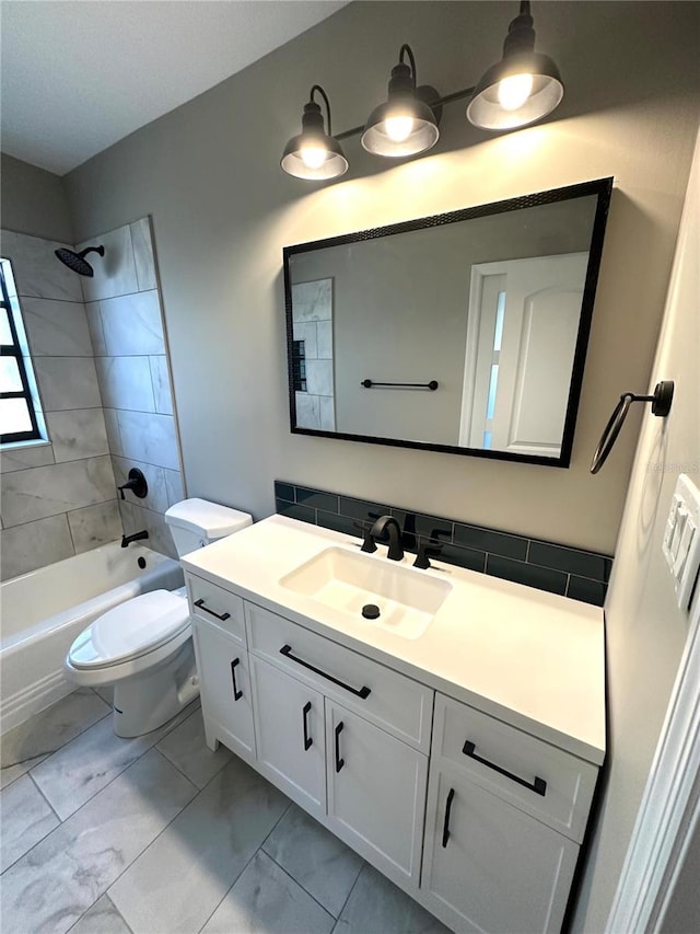 bathroom featuring vanity, marble look tiles, bathtub / shower combination, and toilet