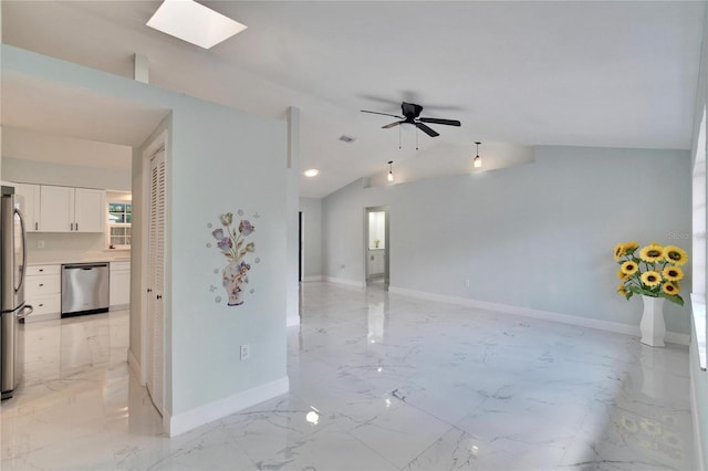 empty room with lofted ceiling with skylight and ceiling fan