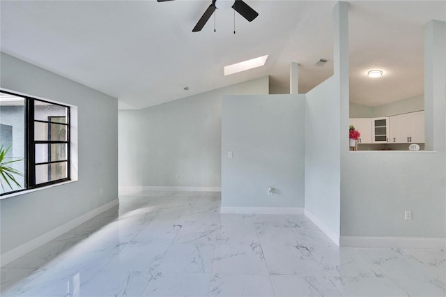 spare room featuring ceiling fan and lofted ceiling with skylight