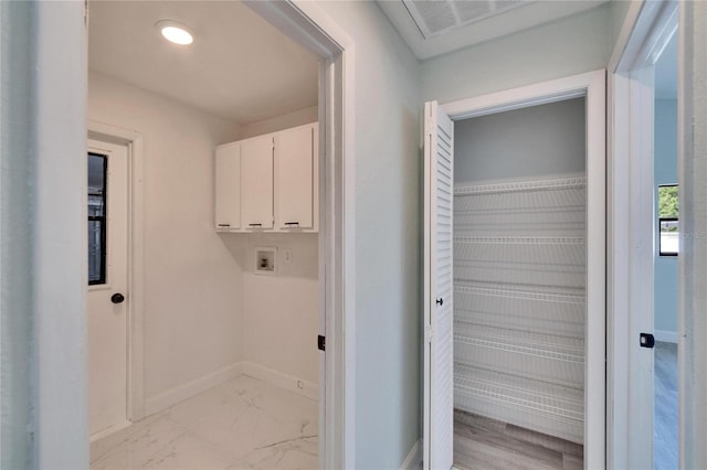 clothes washing area with cabinets and washer hookup